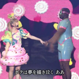 No comment: Kyary Pamyu Pamayu wearing pink poo is holding hands with her latex slave.